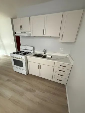 a kitchen with cabinets appliances a sink and a stove