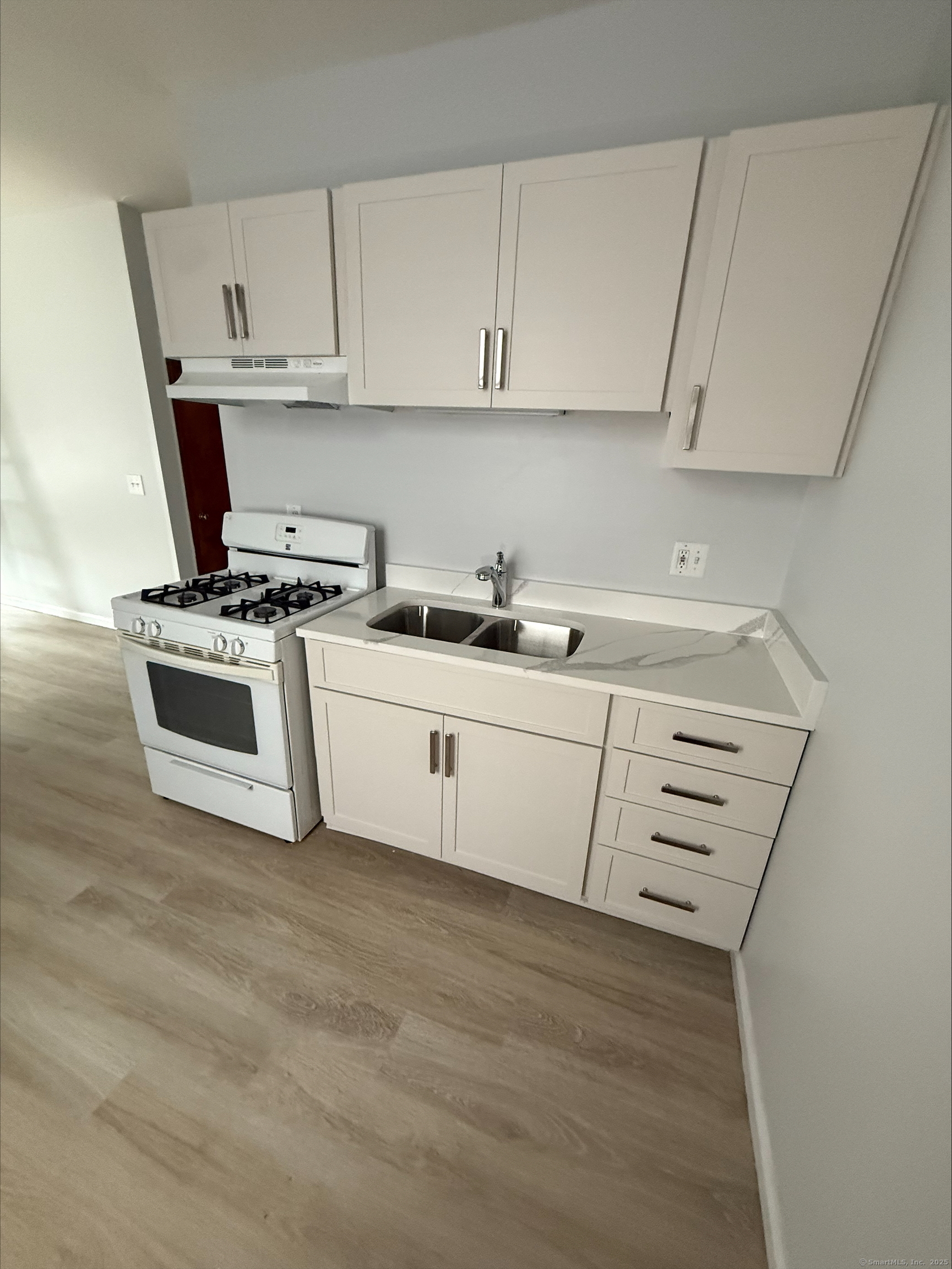 a kitchen with cabinets appliances a sink and a stove
