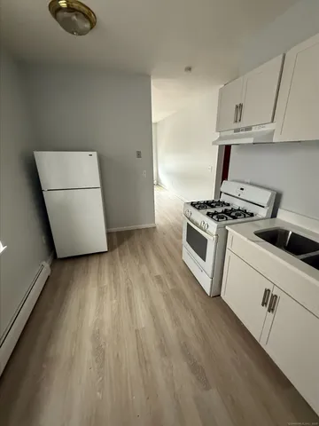 a kitchen with a stove top oven and cabinets