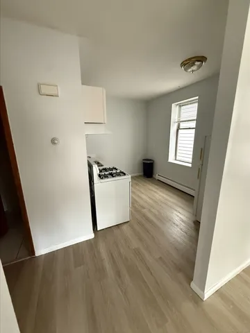 an entryway with wooden floor and cabinets