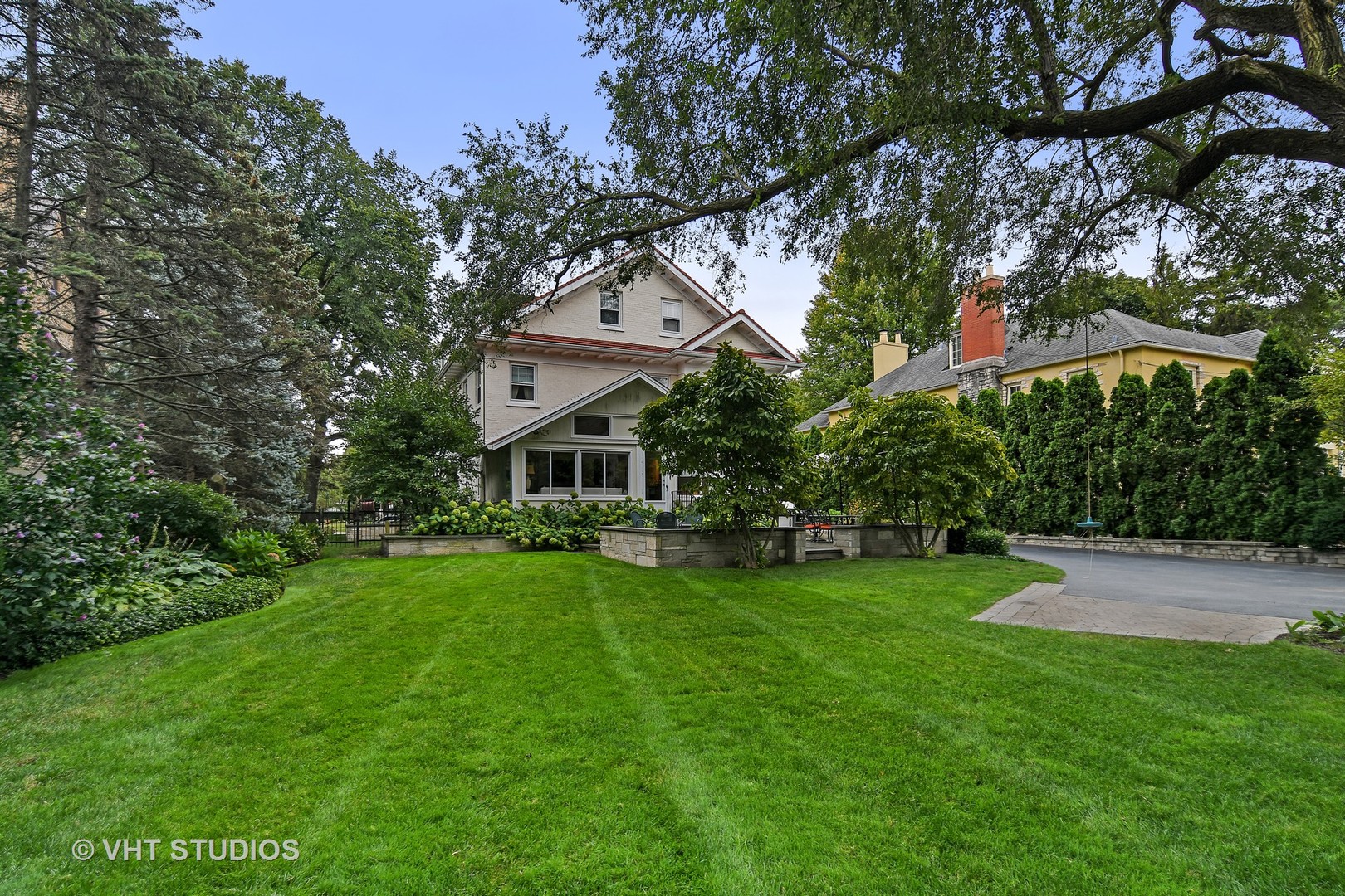 141 Robsart Place Kenilworth, IL 60043 - Photo 22 of 38 a front view of a house with a garden and trees