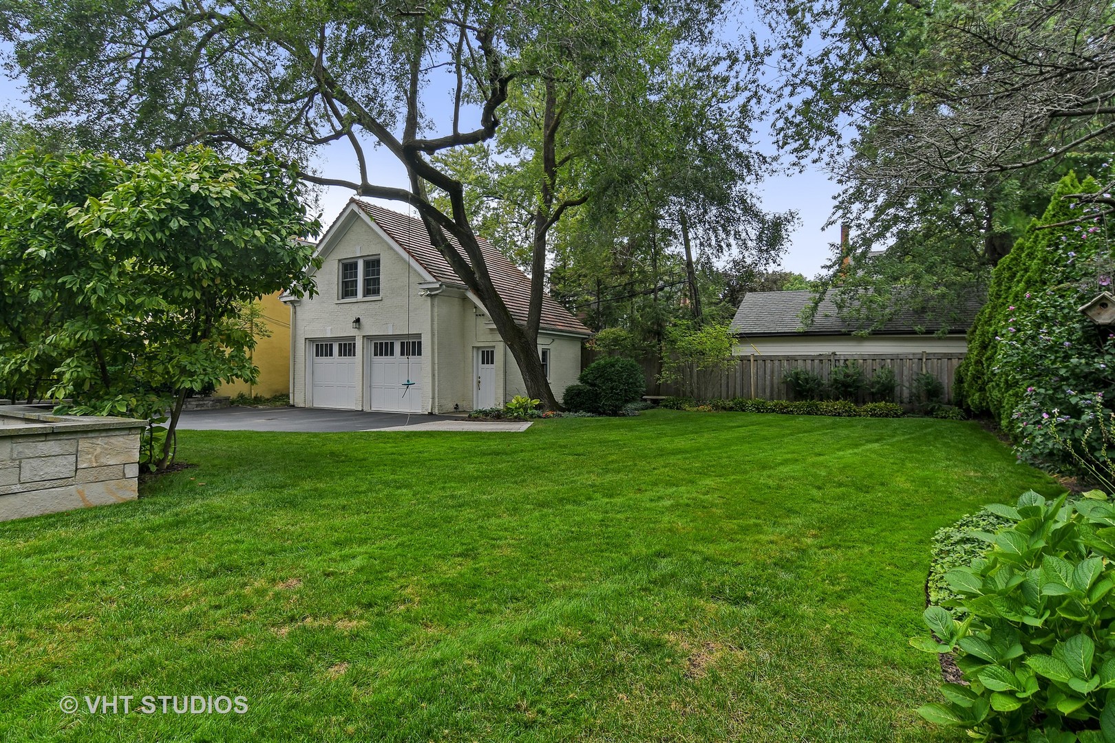 141 Robsart Place Kenilworth, IL 60043 - Photo 23 of 38 a view of a white house in front of a big yard with large trees