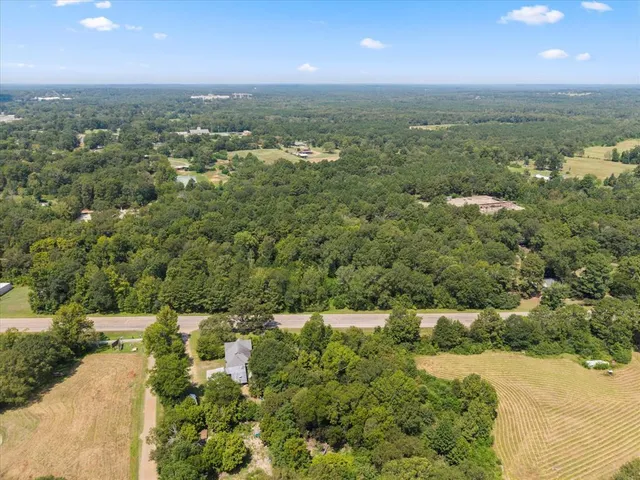 an aerial view of residential houses with outdoor space and trees