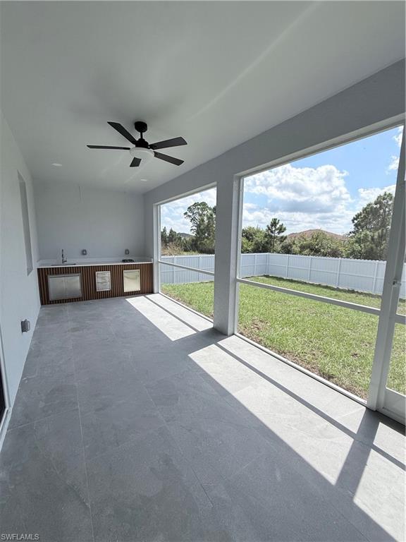 1024 Hatfield Street Lehigh Acres, FL 33974 - Photo 1 of 3 Unfurnished sunroom with a ceiling fan and a patio