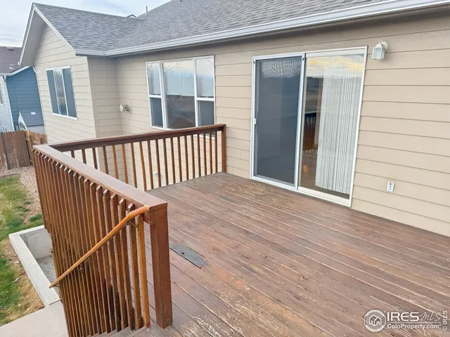 an empty room with wooden floor chandelier fan and windows