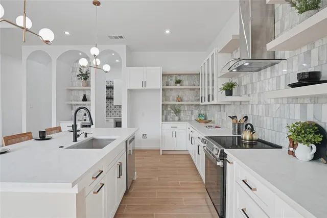 a kitchen with kitchen island granite countertop a sink stainless steel appliances and cabinets