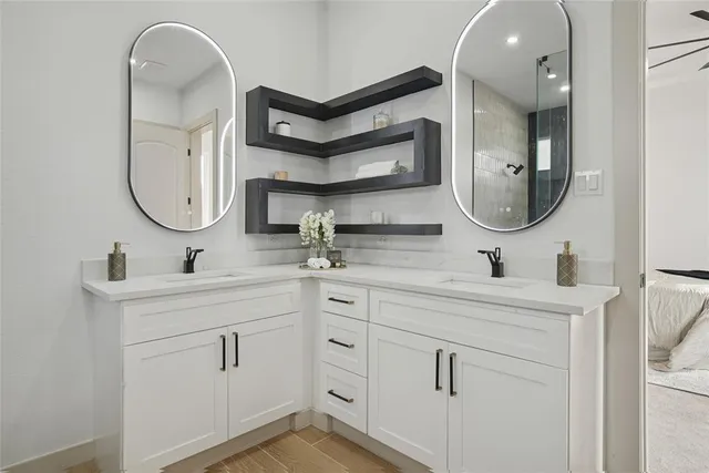 a bathroom with a double vanity sink a toilet and a shower