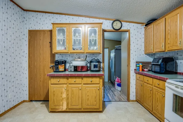 a kitchen with stainless steel appliances granite countertop a refrigerator and a stove top oven
