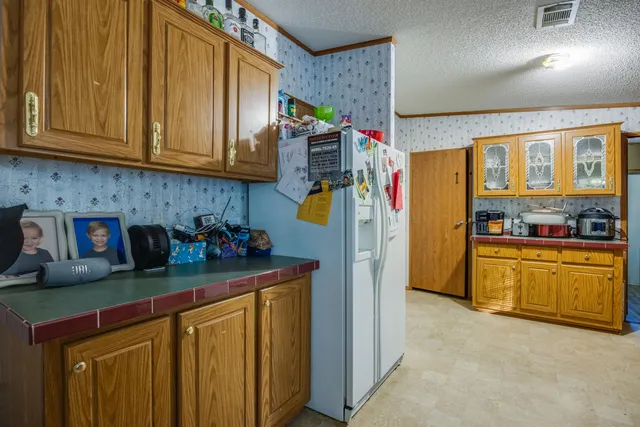a kitchen with stainless steel appliances granite countertop a refrigerator and a stove top oven
