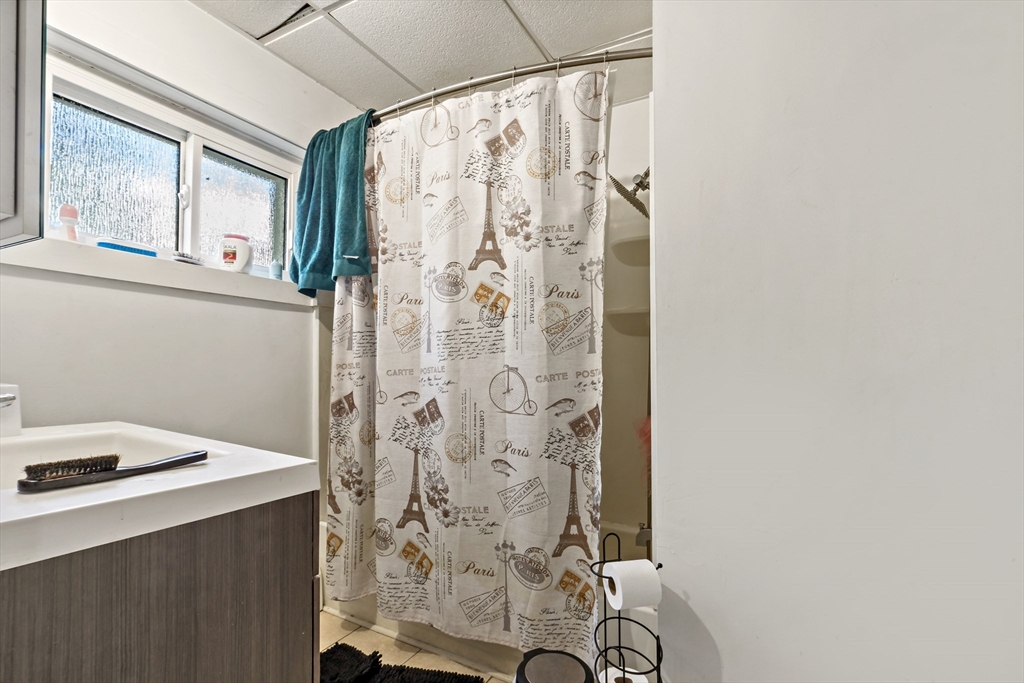 163 Warren Street Fall River, MA 02721 - Photo 19 of 39 a bathroom with a shower curtain and a window