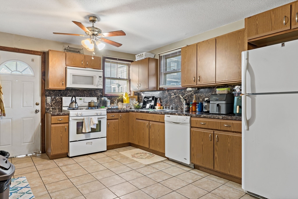163 Warren Street Fall River, MA 02721 - Photo 3 of 39 a kitchen with white cabinets and white appliances