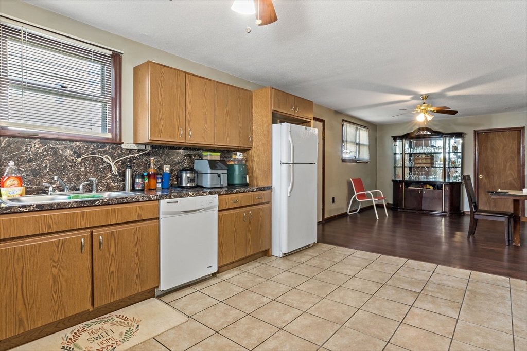 163 Warren Street Fall River, MA 02721 - Photo 4 of 39 a kitchen with a refrigerator a stove cabinets and wooden floor