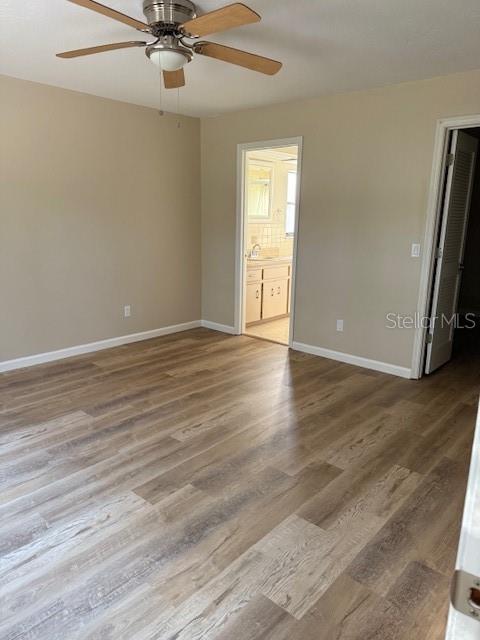 6506 East Mockingbird Lane Inverness, FL 34452 - Photo 5 of 9 an empty room with wooden floor fan and windows
