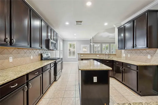 a kitchen with stainless steel appliances granite countertop stove top oven and cabinets