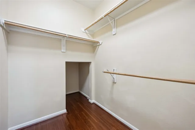 a view of walk in closet with wooden floor