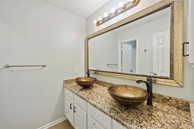 a bathroom with a granite countertop sink and a mirror