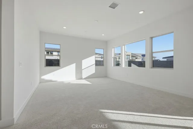 a large white kitchen with a refrigerator and white cabinets