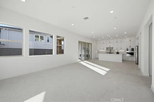 a kitchen with stainless steel appliances a refrigerator a sink and white cabinets