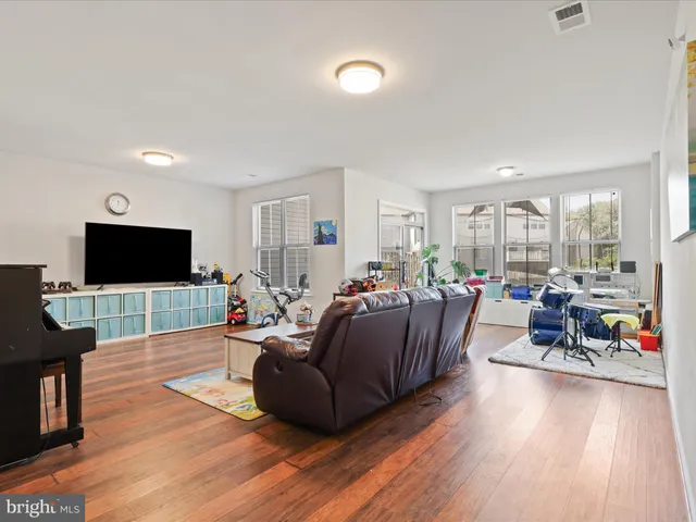 a living room with furniture a flat screen tv and a large window