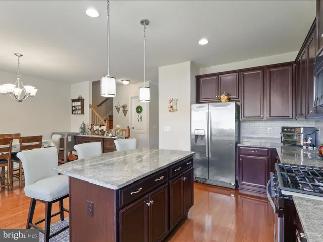 a kitchen with stainless steel appliances granite countertop a kitchen island a table and chairs