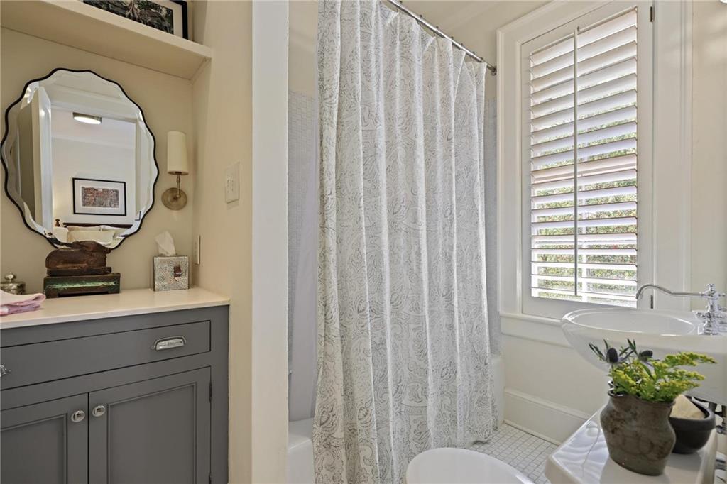 10 Palisades Road Northeast Atlanta, GA 30309 - Photo 30 of 49 a bathroom with a toilet a sink a mirror a shower and vanity
