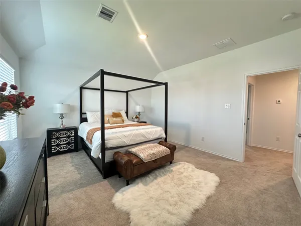a bedroom with a bed and a potted plant