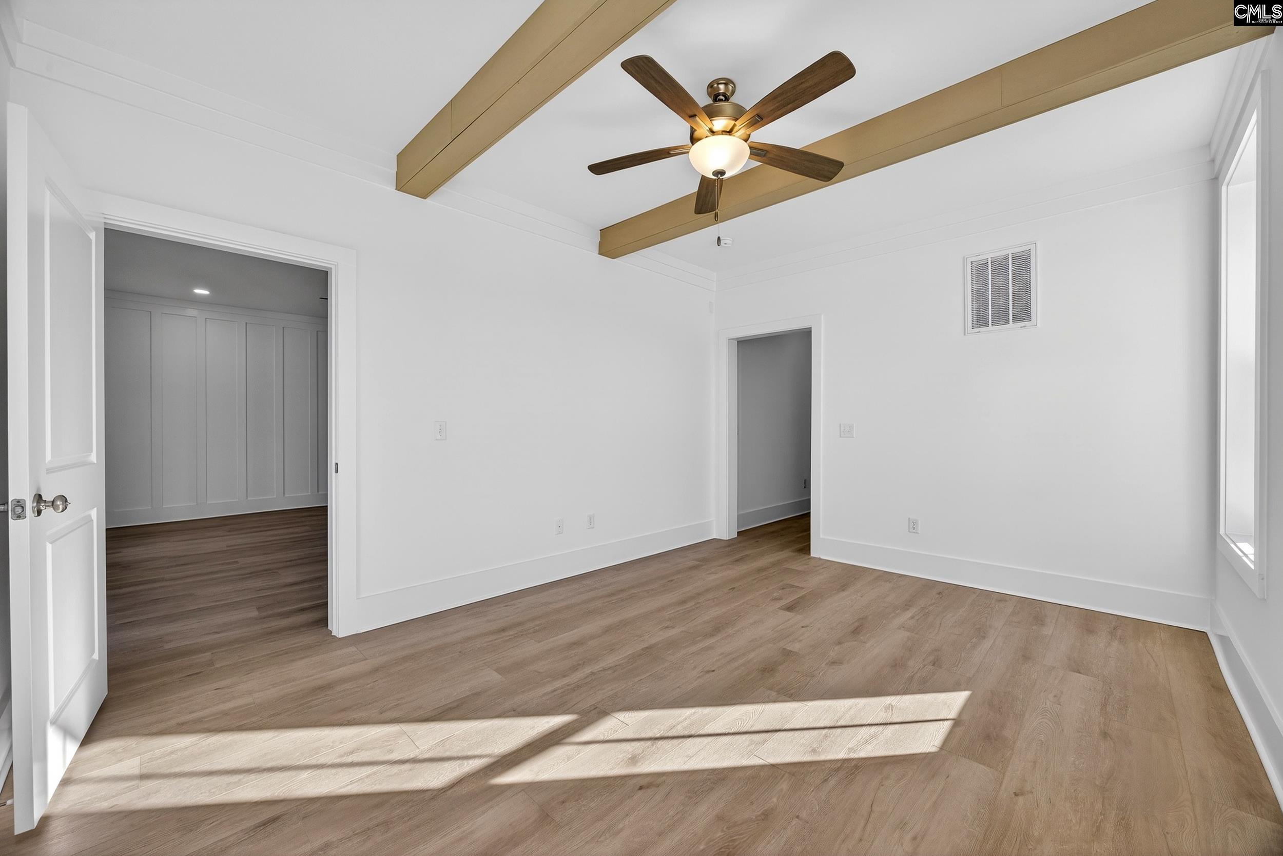 1318 Long Grove Way Lexington, SC 29072 - Photo 41 of 90 an empty room with wooden floor ceiling fan and a ceiling fan