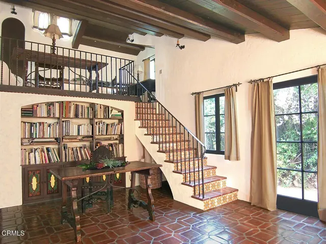 a view of staircase with lots of frames on wall and a window