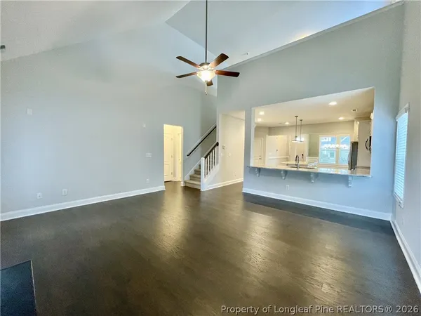a view of a livingroom with a ceiling fan and hardwood floor