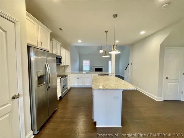 a large kitchen with stainless steel appliances kitchen island granite countertop a refrigerator a stove and a sink