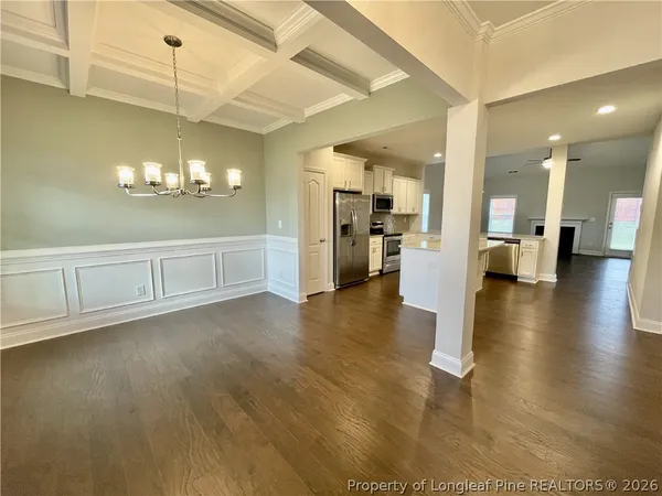 a view of a livingroom with wooden floor and white cabinets