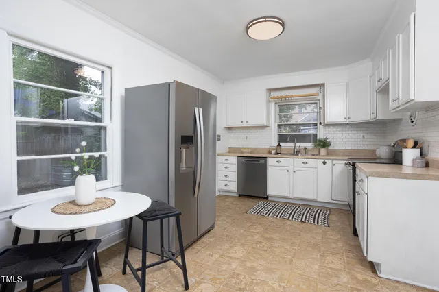 a kitchen with cabinets appliances and a window