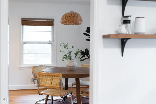 a dining room with table chairs and wooden floor
