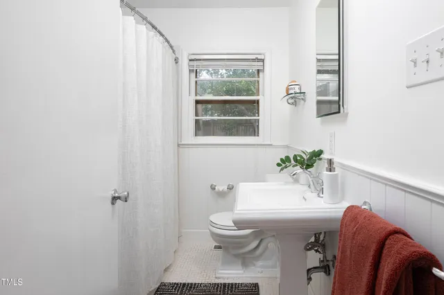 a bathroom with a sink mirror and toilet