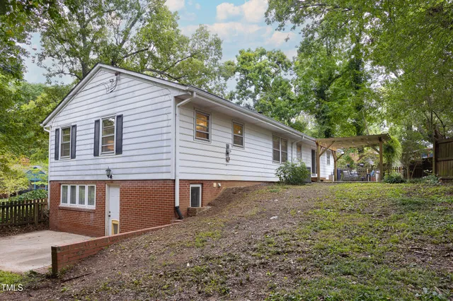a view of a house with a yard and sitting area