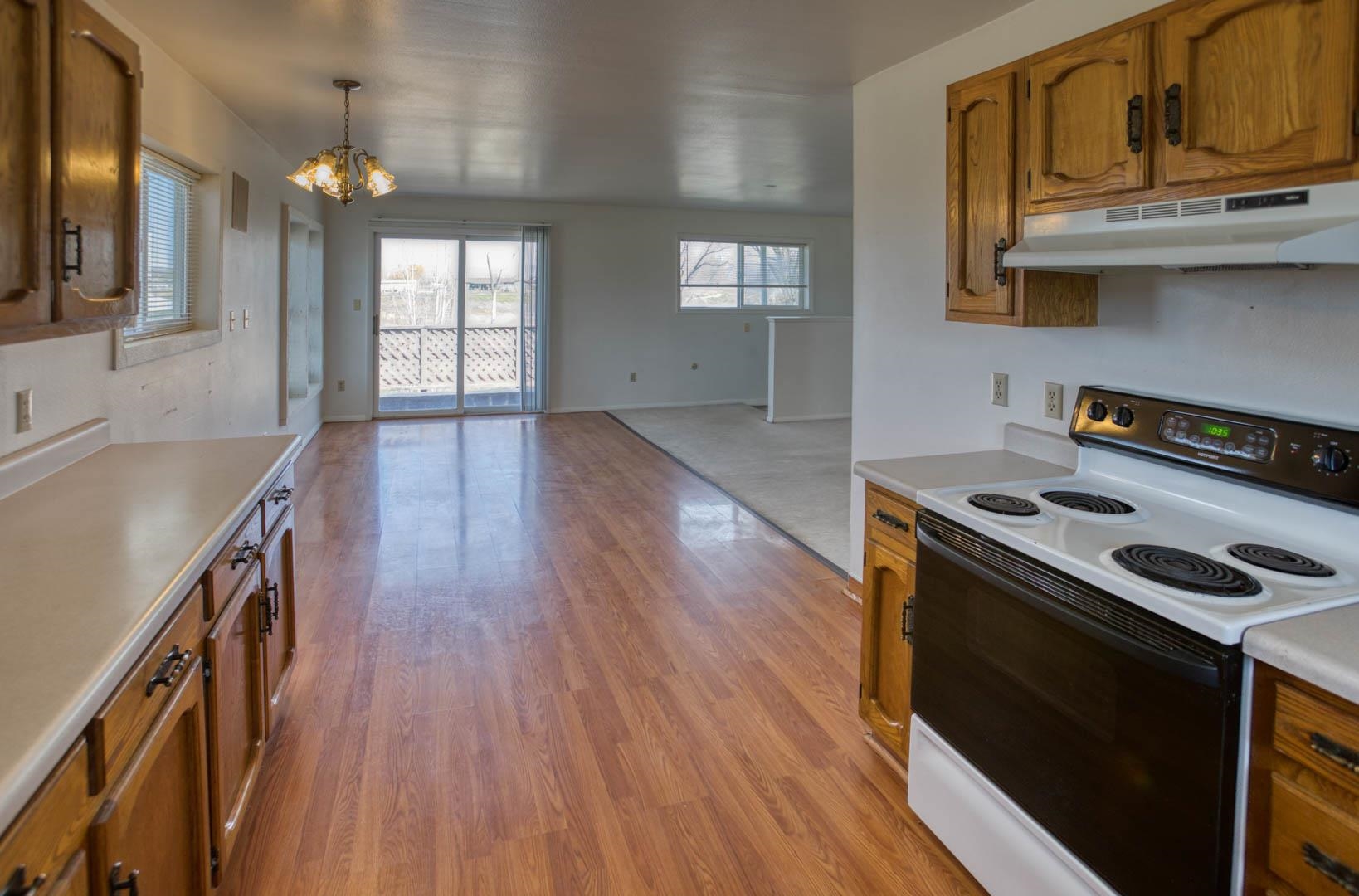 1179 17 Road Fruita, CO 81521 - Photo 26 of 36 a kitchen with granite countertop a stove and a wooden floors
