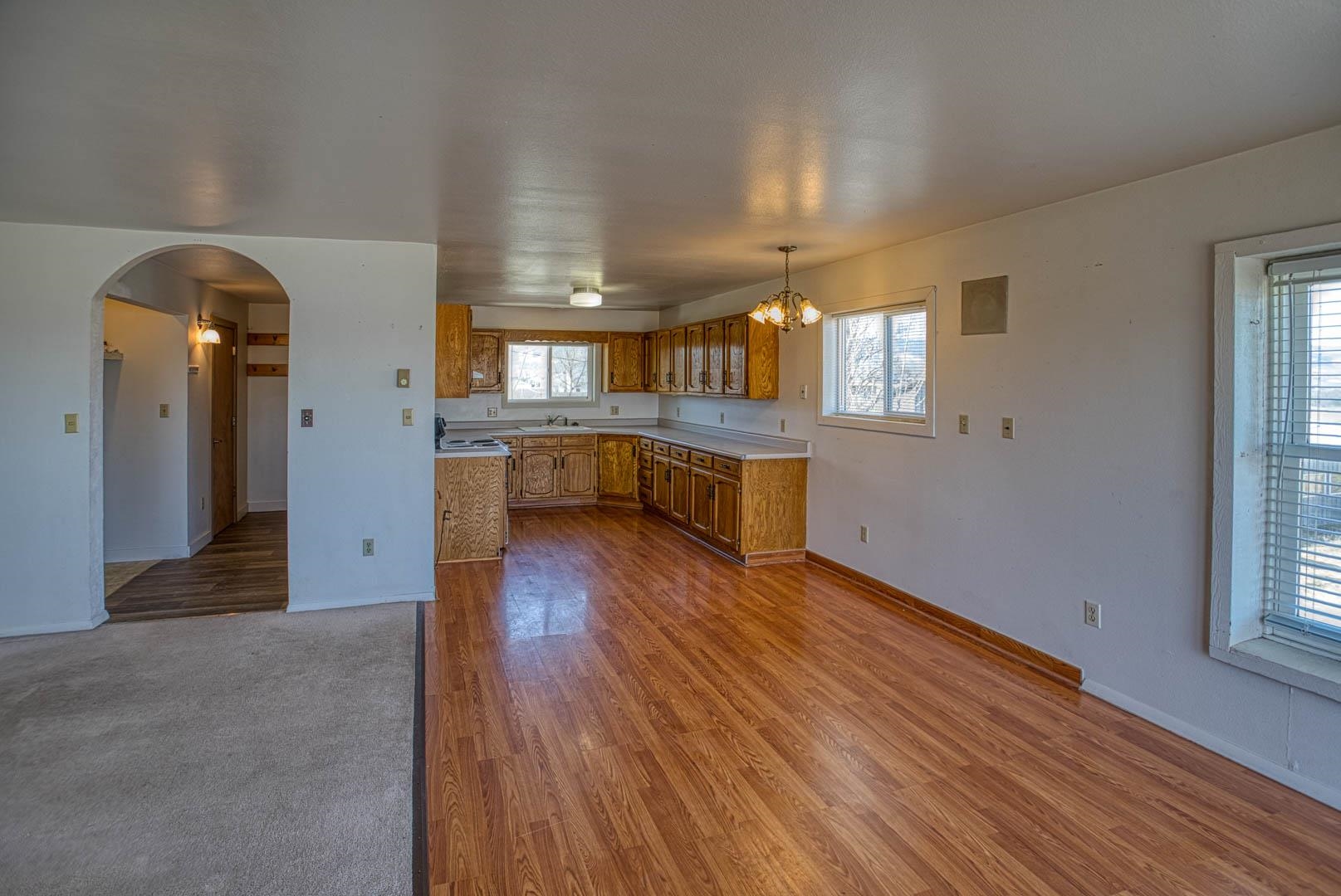 1179 17 Road Fruita, CO 81521 - Photo 28 of 36 a view of a hallway with wooden floor and a kitchen