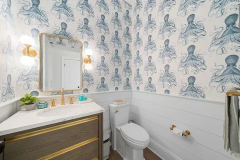 a bathroom with a sink mirror vanity and toilet