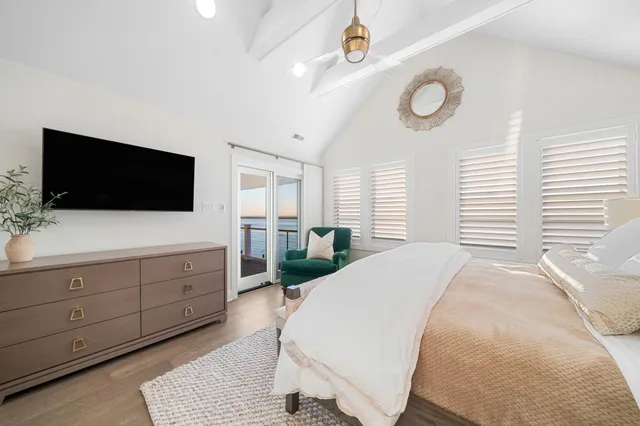 a spacious bedroom with a bed and a flat screen tv