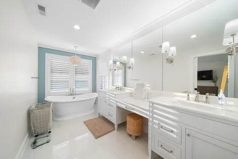 a bathroom with a granite countertop sink mirror and a bathtub