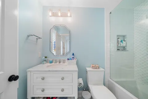 a bathroom with a sink vanity mirror and toilet