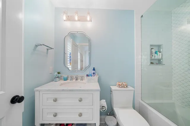 a bathroom with a sink vanity mirror and toilet