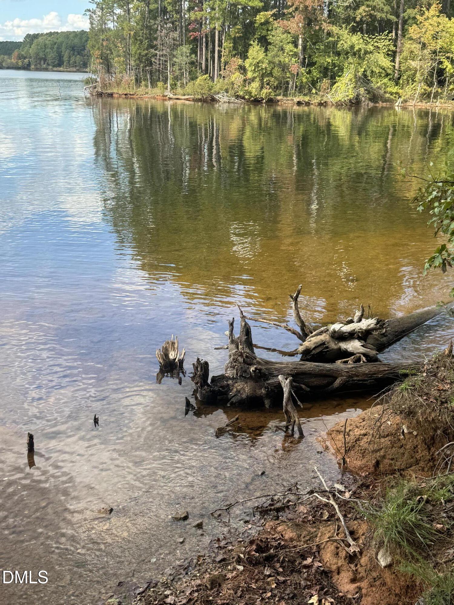 0 New Mayo Drive Roxboro, NC 27574 - Photo 25 of 27 a view of a lake with lawn chairs and an umbrella