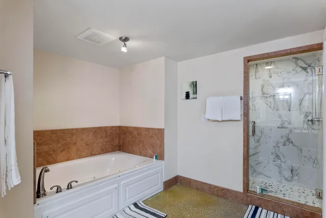 a bedroom with a large bed and a chandelier