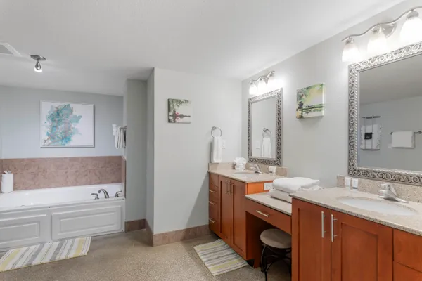 a bathroom with a tub a sink and glass door
