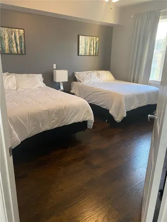 a bedroom with two beds and wooden floor