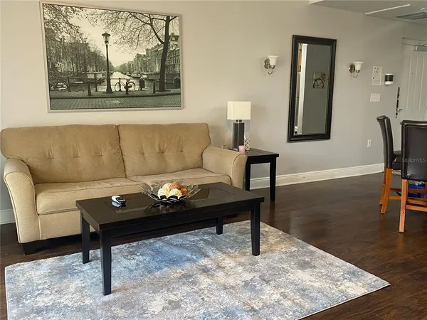 a living room with furniture and a wooden floor