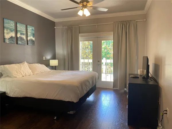 a bedroom with a bed and a flat tv screen on dresser