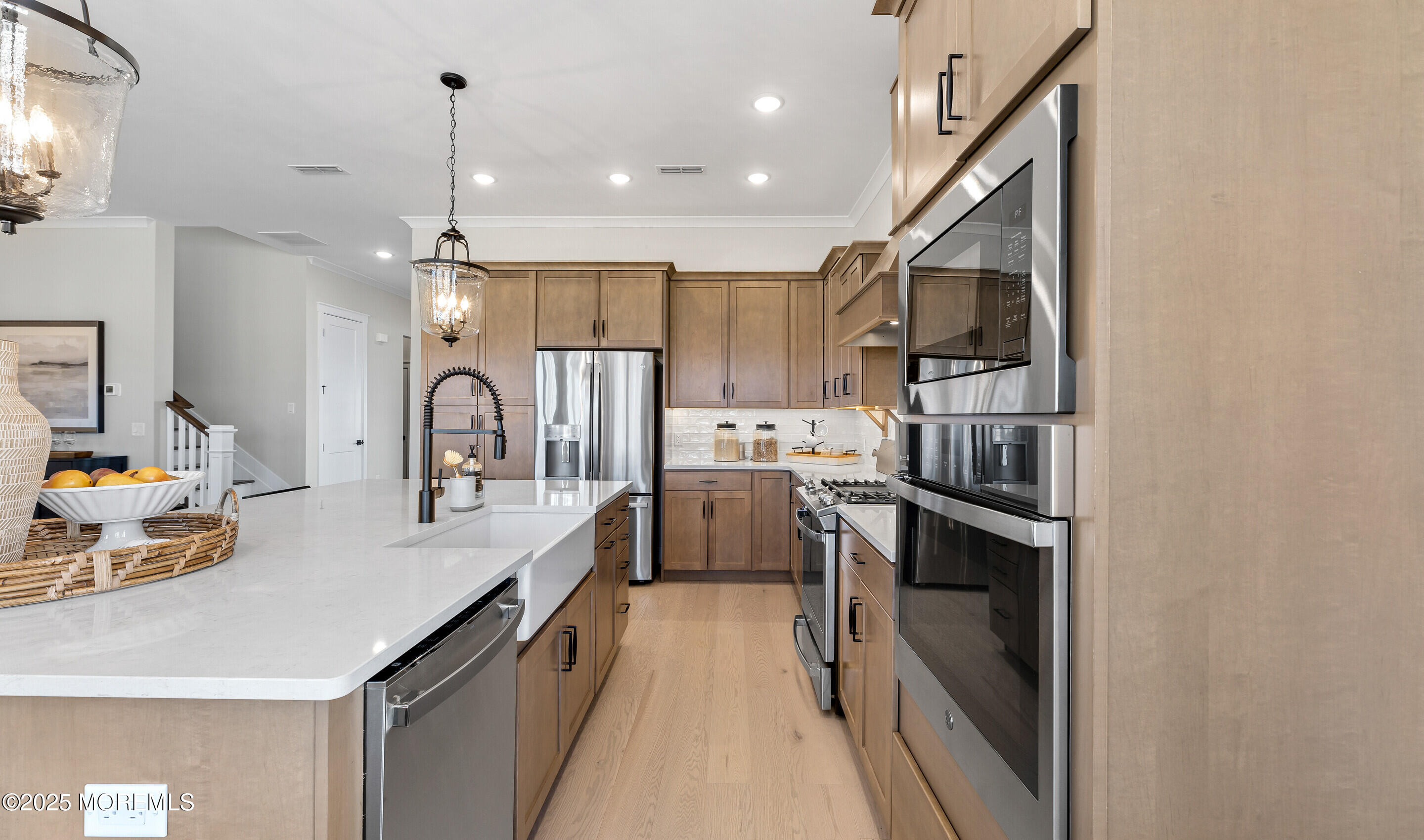 176 Highway 33, Unit DORCHESTER LOFT Manalapan, NJ 07726 - Photo 17 of 38 a kitchen with white cabinets and stainless steel appliances