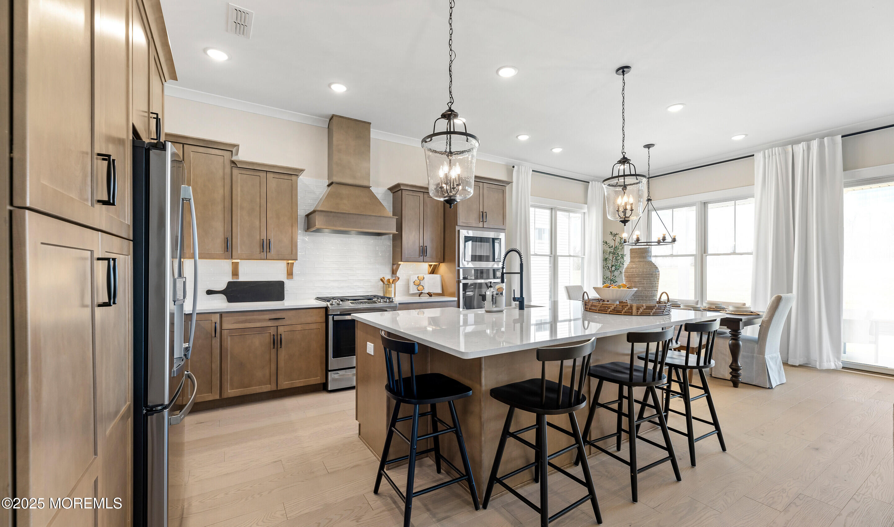 176 Highway 33, Unit DORCHESTER LOFT Manalapan, NJ 07726 - Photo 20 of 38 a kitchen with stainless steel appliances kitchen island granite countertop a dining table chairs refrigerator and microwave